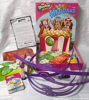 Front view of open box showing headbands, cards, tokens, instructions