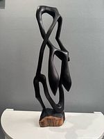 Front view of ebony abstract sculpture on base