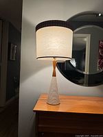 Full view of lamp on table, shade lit