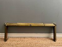 Full view of brass fireplace fender showing adjustable front rail and legs