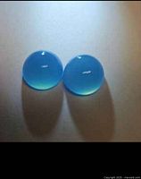 Two round blue chalcedony cabochons side by side displaying color