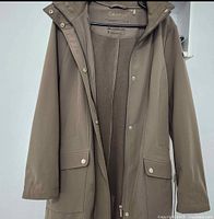 Front view of taupe Calvin Klein waterproof jacket on hanger