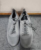 Top view of both shoes showing grey knit upper and lacing