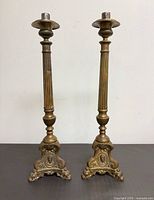 Front view of both brass candlesticks showing full height and base detail
