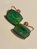 Front view of both earrings showing green carved cabochons and screw backs