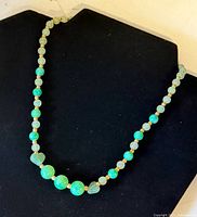 Necklace displayed on black bust showing overall form and bead graduation