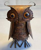 Front view of mixed metal owl sculpture showing eyes, feathers, and ear tufts