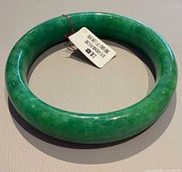 Top view of green jade bangle with tag