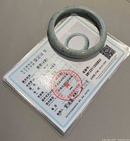 jade bangle resting on laminated certificate