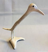 Side view of carved bone bird sculpture standing