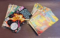 Two stacks of assorted Marvel comics, top copy Silver Surfer #50 style cover visible