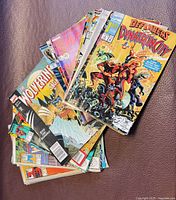 Stack of assorted Marvel comic books including Wolverine titles, Defenders of Dynatron City and Fantastic Four