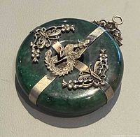 front view of jade disc pendant with dragon and floral appliqués