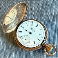 Open pocket watch showing dial and inner lid