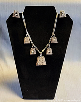 Necklace on display bust with earrings to show complete set