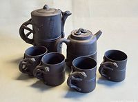 Full set front view showing both teapots and four cups