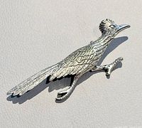 Front view of silver-tone roadrunner brooch