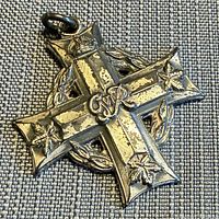 Front of sterling Canadian Memorial Cross showing royal cypher and maple leaves