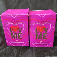 Two sealed Baby Phat Love Me perfume boxes front view