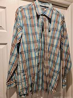 Full view of plaid long-sleeve Cinch shirt hanging.