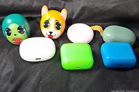 Group of seven earbud cases in assorted colors and shapes