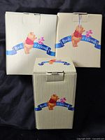 Front view of three Pooh & Friends striped boxes