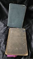 Front covers of both antique books, showing wear