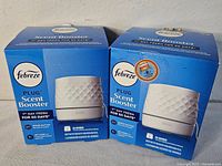Front view of two boxed Febreze Plug Scent Booster oil warmers