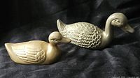 Both brass duck figurines side by side