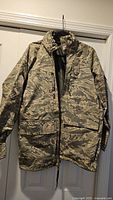 Front view of camouflage parka on hanger