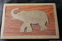Top view of closed box showing brass elephant inlay and border