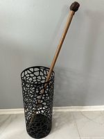 Full view of cylindrical black cutout metal umbrella stand