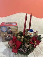 Boxed illuminated musical snowman and Christmas centerpiece on sofa