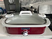 Front view of red Crock-Pot rectangular slow cooker with lid and clamps