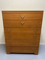 Front view of mahogany dresser showing five drawers and brass pulls