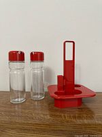 Full view of two bottles and red plastic caddy