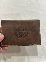 front view showing embossed Roots logo on brown leather