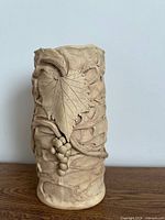 Reverse side showing grape leaf and grape cluster relief