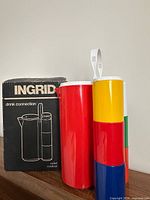 Box, red pitcher, stacked tumblers visible
