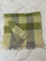Folded plaid mohair scarf showing overall pattern and fringes