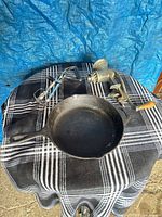 Top view showing cast iron skillet, Universal food chopper, rotary egg beater on cloth