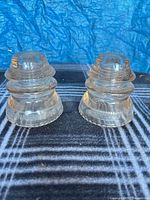 Front view of both clear glass insulators marked Dominion
