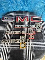 Overall view of all seven emblems on plaid background