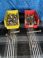 Yellow and red bins holding numerous bolts and nuts
