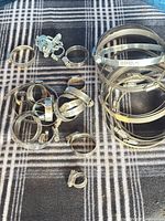 Group of assorted metal hose clamps scattered and stacked