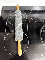 Full view of grey marble rolling pin on stovetop