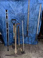 Full view of seven tools leaning against tarp