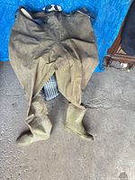 Full view of chest waders laid flat showing boots and overall wear