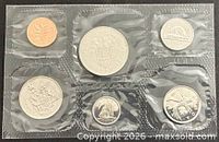 Front view of sealed 6-coin set showing reverse designs including BC dollar