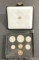 Open case displaying seven coins in flock tray and satin lid with Royal Canadian Mint logo